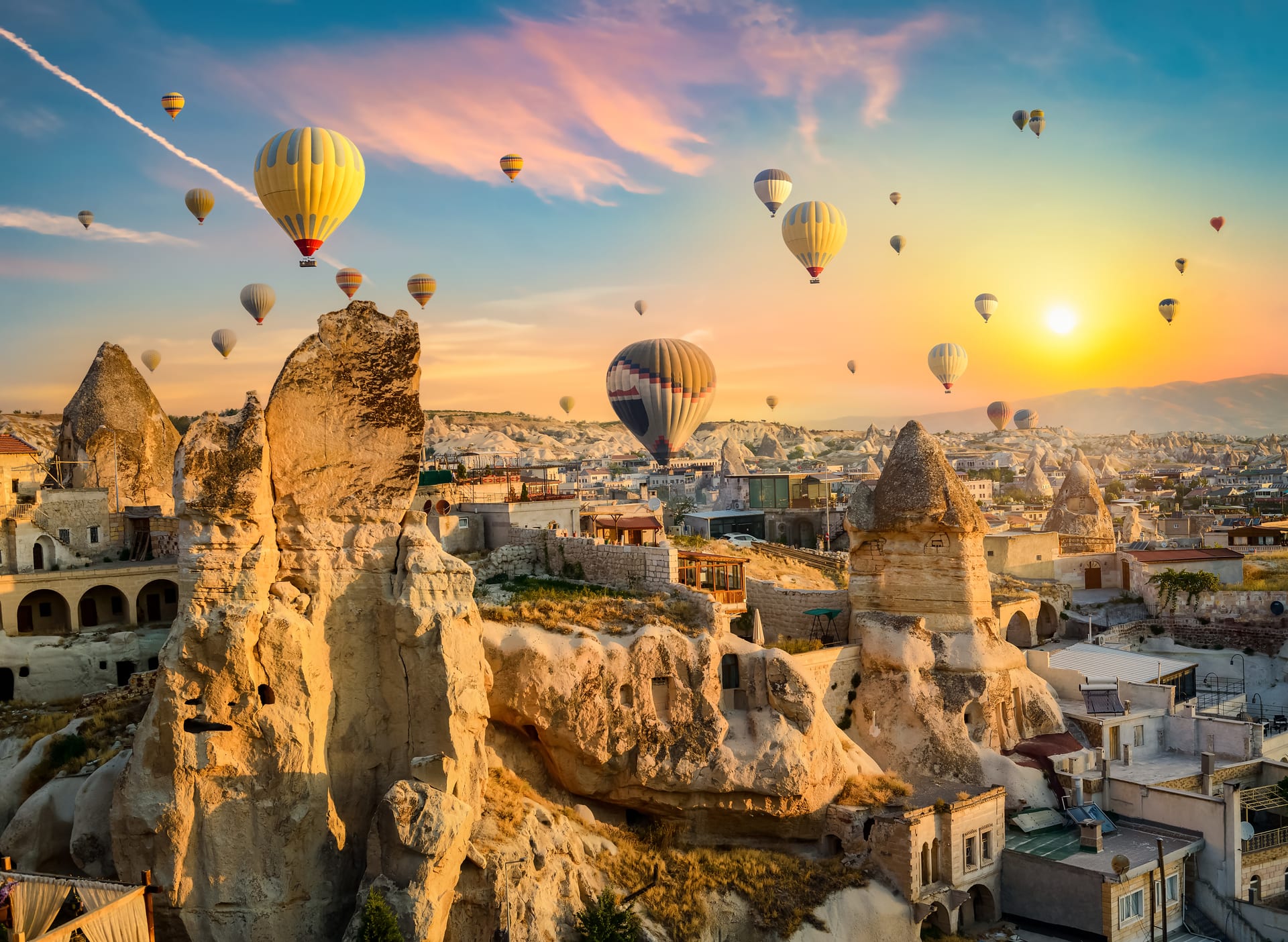 Hot air balloons floating over Cappadocia fairy chimneys at sunrise
